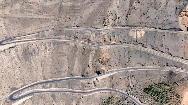 Birds eye aerial drone shot of the zigzagging Ka Loops mountain pass and highway in Himachal Pradesh, India.