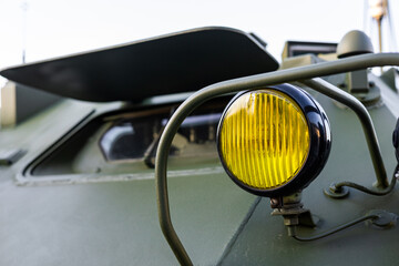 Obraz premium Military equipment and army equipment.. Industrial armored vehicle headlight showing wear and protective features. Detailed view of combat vehicle headlight emphasizing ruggedness