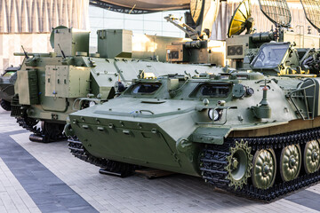 Military equipment and army equipment.. Lined armored vehicles on display showing multiple tracked carriers on paved platform, olive green paint, turret silhouettes and strategic © NastyaPhoto