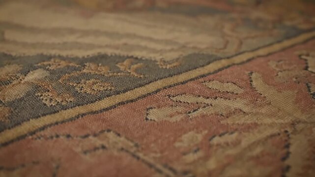 Close-up of an antique Persian rug with intricate patterns and frayed edges.