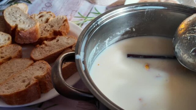 Traditional Spanish torrijas preparation with bread slices soaking in milk bowl on rustic table ready for Easter holiday dessert cooking