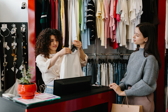 Shop assistant helping customer with clothing selection