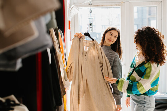 Young women shopping for clothes, choosing new fashion apparel