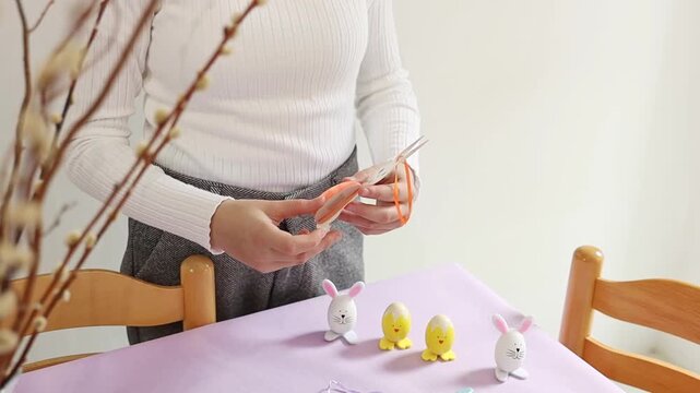 One girl makes a paper Easter toy by hand.