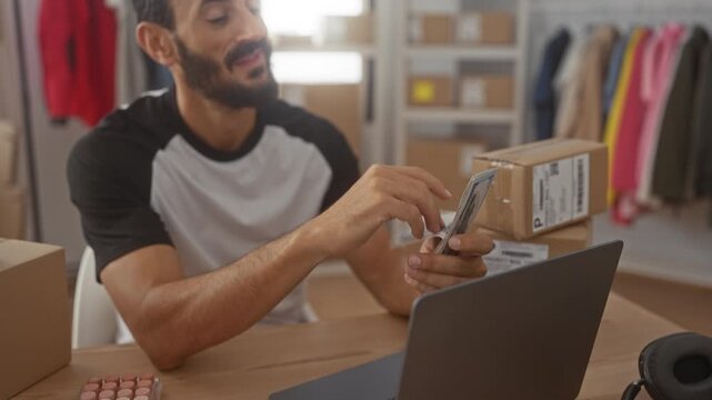 Man counting cash with hands while packing cardboard shipping boxes at a small e commerce studio workspace with laptop and labels; entrepreneur pride.