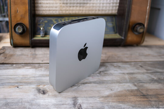 Mac Mini M1 Apple computer held, retro radio, old and new technology portability, vintage aesthetic, working remotely in cozy home environment, Frankfurt - February 4, 2025