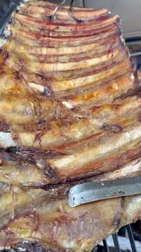 cortando costillar ancho, asado parrilla argentina
