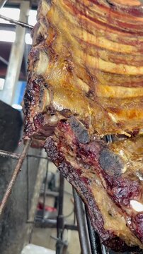 cortando costillar ancho, asado parrilla argentina