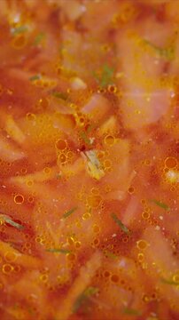 Rustic dish with tender vegetables. Steaming bowl of flavorful borscht stew. Closeup view of simmering red borscht filled with fresh shredded beets potatoes and carrots