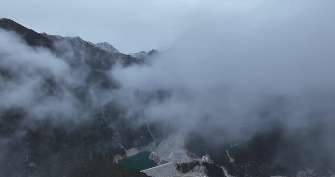 Aerial footage of beautiful high altitude snowcapped mountains and forest landscape	
