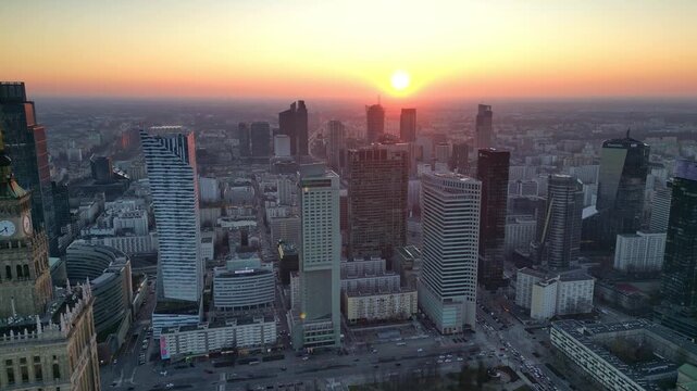 Warszawa - Polska - niesamowita panorama miasta podczas zachodu słońca, drapacze chmur, zach&oacute;d słońca, ulice miasta, wierzowce nagrane dronem, kinowe ujęcia, dobra jakość