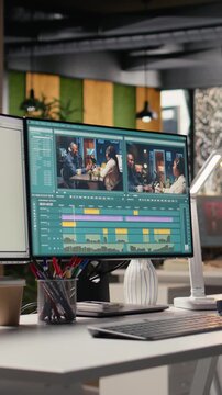 Vertical Video No people highlights workstation with video editing software on footage project, PC shows raw recorded clips and toolbar icons, effects panels and adjustment controls. Film production