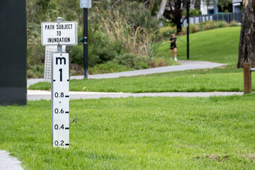Flood level marker indicating path subject to inundation in a public park in Maribyrnong Australia....