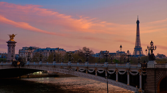 Eiffel Tower and Pont Alexandre III at spring sunset over Seine river in Paris