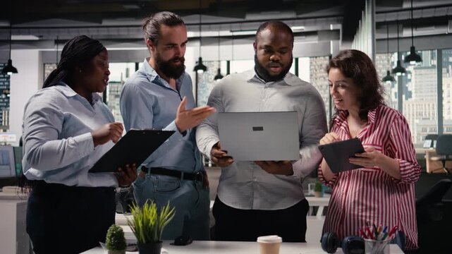 Multiethnic group of colleagues working on marketing strategy with reports, sharing ideas and insights for business management and administration. Diverse people making decisions.