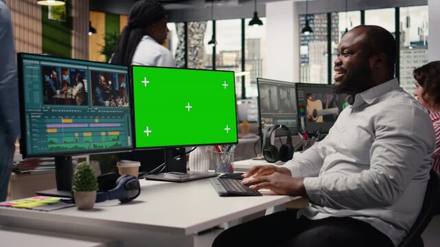 Green screen, editing software workflow, filmmaker cutting raw clips, in a creative agency office. Black man using motion graphics tools and playback controls for professional visual effects.