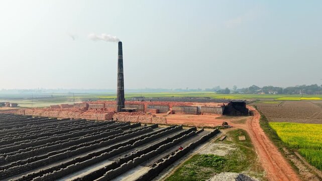 Brick factory with a smokestack and rows of bricks industrial site construction manufacturing pollution environment