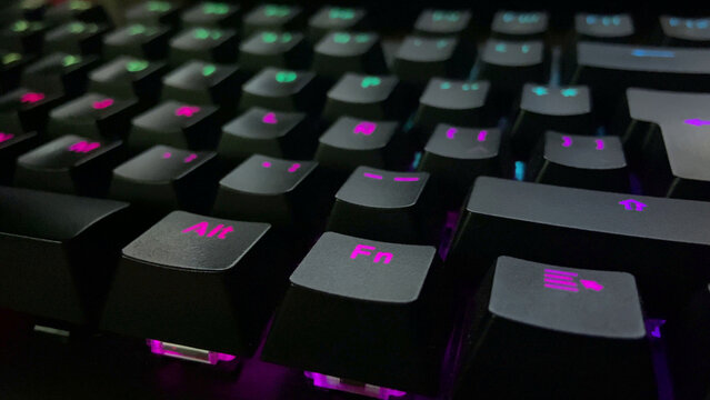 Mechanical gaming keyboard with vibrant pink and teal RGB backlighting