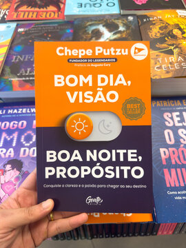 BELO HORIZONTE, MG, BRAZIL, MARCH 31, 2026. The motivational self-help book "Bom Dia, Vis&atilde;o. Boa Noite, Prop&oacute;sito" by Chepe Putzu, with its striking orange and purple cover, is shown in a bookshop.