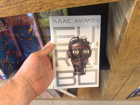 BELO HORIZONTE, MG, BRAZIL, MARCH 31, 2026. A person's hand proudly holds up "Isaac Asimov: Eu, Rob&ocirc;," displaying its striking white cover and robot illustration.