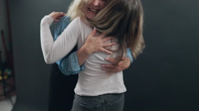 Joyful mother and daughter laughing while embracing tightly