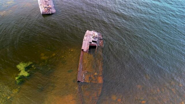 Aerial view of a rusty ship used as a military target for shooting practice. Abandoned navy target on Lake Ladoga shore.