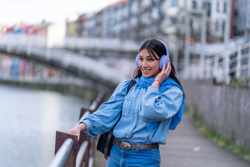 Young woman enjoying music with headphones outdoors smiling © Ceballos
