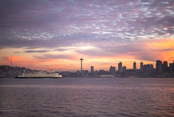 Naklejka premium A commuter ferry passing the Seattle skyline in Elliott Bay at sunrise 