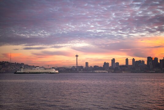 A commuter ferry passing the Seattle skyline in Elliott Bay at sunrise 