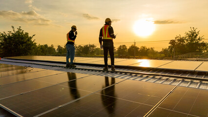Silhouette of two engineers using a drone to inspect a solar panel roof at sunset. Professional team surveying renewable energy infrastructure during golden hour. © ultramansk