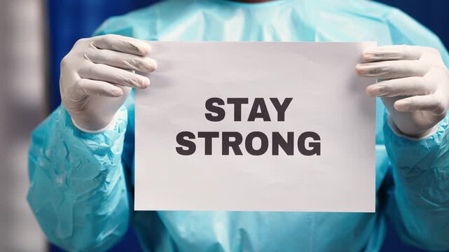 Healthcare professional wearing ppe holding a sign of encouragement