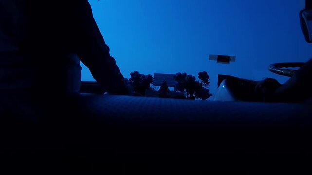 Point-of-view shot from inside a vehicle showing dashboard silhouettes against early morning light. The scene captures calm driving atmosphere, daily commute, and outdoor road environment.