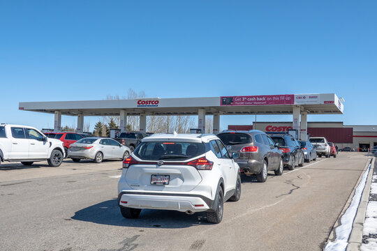 Calgary, Alberta, Canada. April 9, 2026. Vehicles line up at a Costco Wholesale gas station to refuel on a clear, sunny spring day.