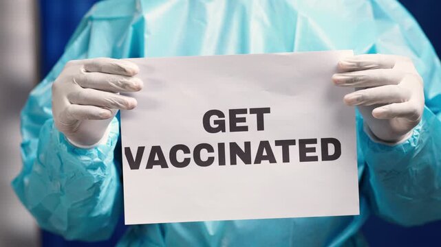 Healthcare worker holding a poster promoting immunization and worldwide public health