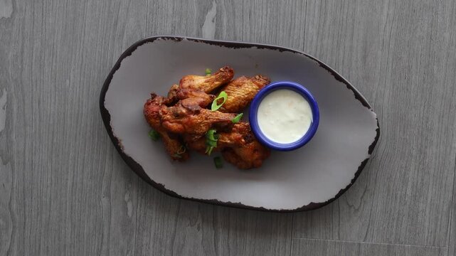 Eating a Plate of Buffalo Chicken Wings and Blue Cheese Dressing