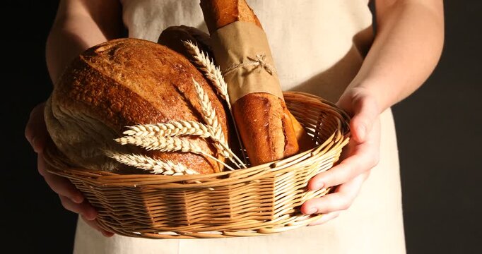Woman with different types of bread on dark background, closeup