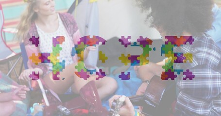 Playing acoustic guitar, friends holding mugs on blanket near tent boots visible HOPE graphic © vectorfusionart