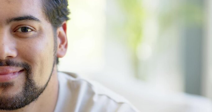 African American man smiling into laughter, shifting by sunlit home window and plant, copy space