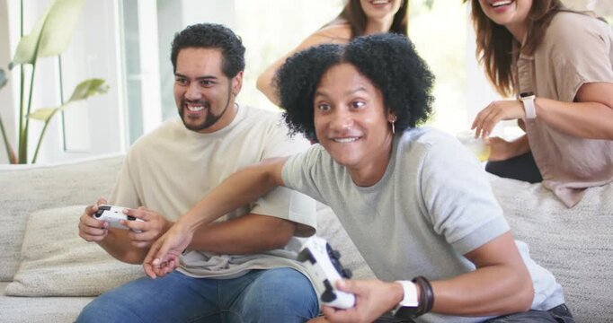 Vertical video: Game starting, two players holding controllers leaning as two women cheering to win