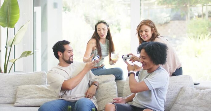 Diverse friends gesturing controllers, then passing controllers and beer bottles on couch, chatting