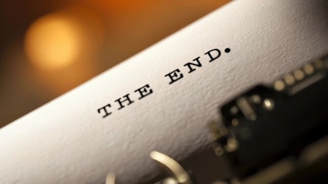 Macro shot of vintage typewriter with The End typed on paper