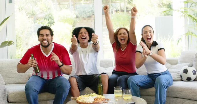 Diverse friends in jerseys cheering clapping hugging on couch after onscreen goal soccer ball near