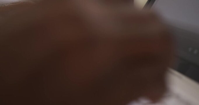African American man hovering finger then moving hands, tapping keys on laptop at desk, working