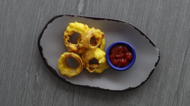 Serving a Plate of Fried Onion Rings with Dipping Sauce