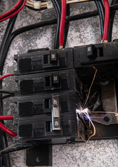 Residential electrical load center, with a fault in the thermomagnetic circuit breaker causing a spark in one of its phases due to a bad connection (loose connection) between the terminals of the swit © Victor
