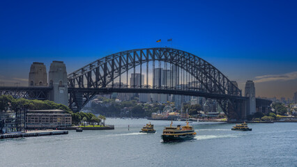Naklejka premium Title: View of Sydney Harbour and Circular Quay and Sydney Harbour Bridge in on beautiful Autumn Afternoon beautiful Sky Sydney NSW Australia