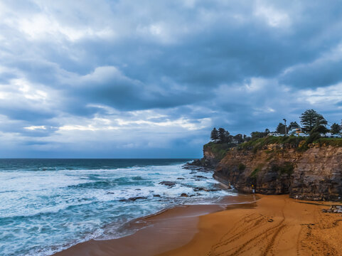 Seaside Sunrise with rolling waves and rain clouds