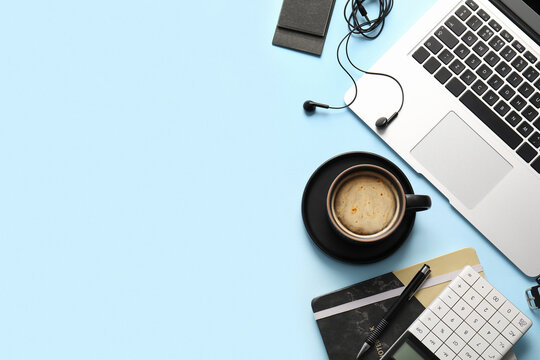 Cup of coffee, laptop and calculator on blue background