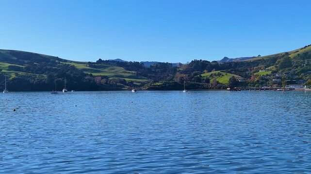 Scenic View of Calm Blue Water and Green Rolling Hills