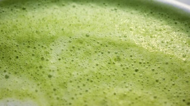 Macro shot of matcha latte foam with smooth creamy texture and soft latte art details